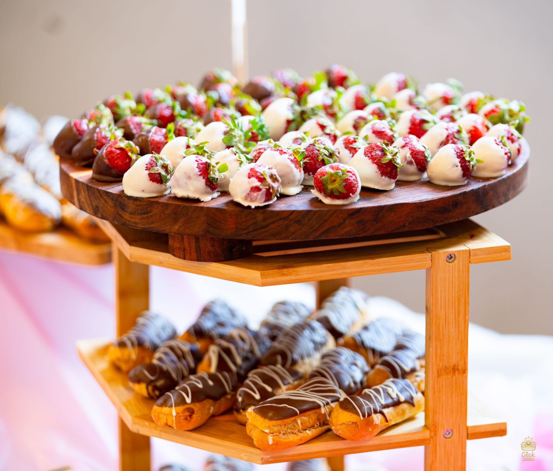 Chocolate-dipped strawberries and eclairs on a tiered dessert stand