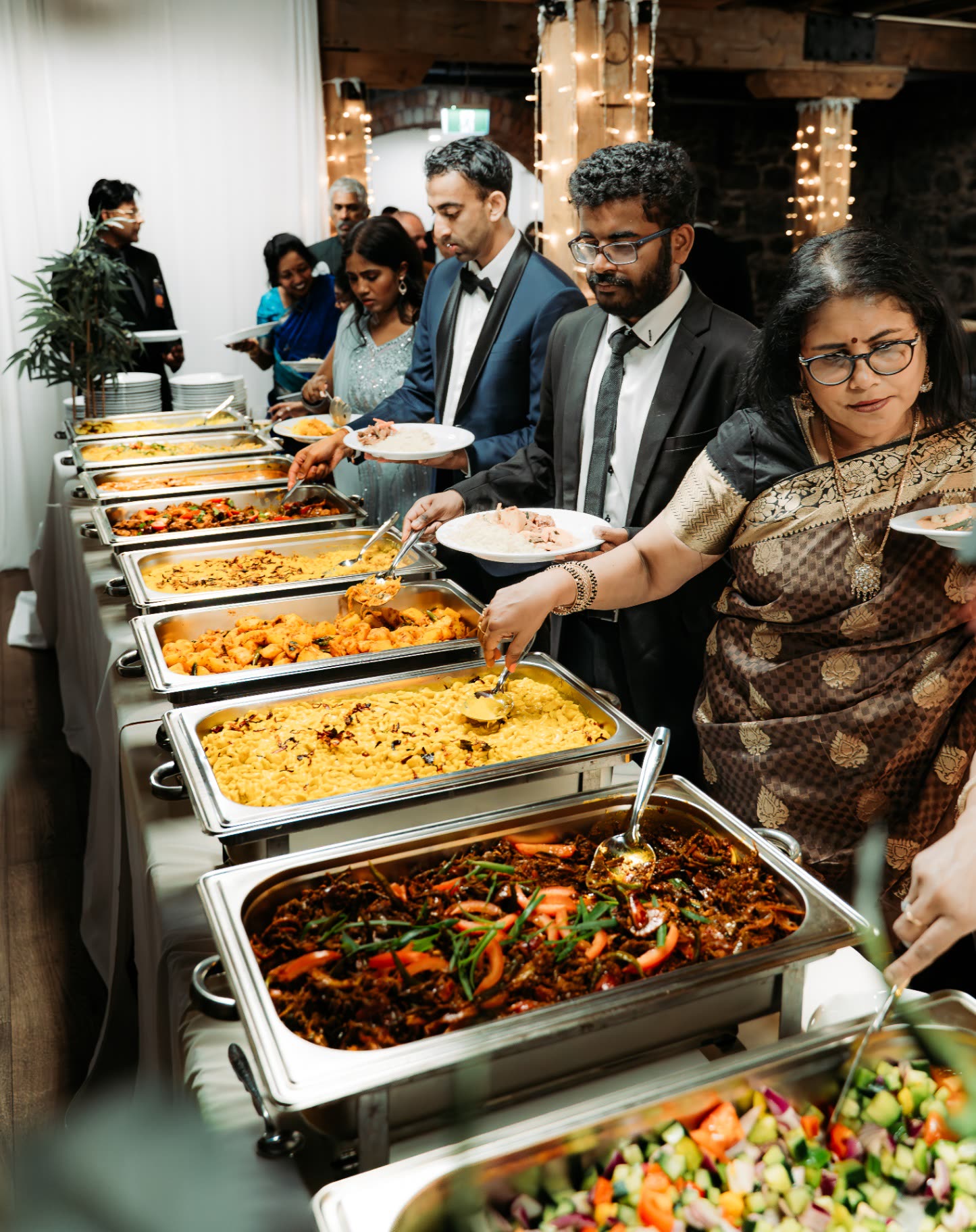 Guests serving themselves from a long Sri Lankan buffet line